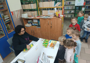 Dzieci wypożyczają książki w bibliotece