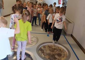 Dzieci idą po ścieżce sensorycznej