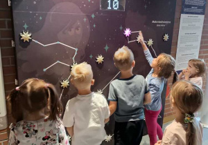 Dzieci układają gwiazdozbiory na wielkiej ścianie