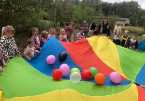 Dzieci bawią się chustą animacyjną, na której są balony