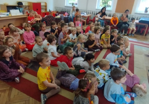 Dzieci siedzą na dywanie