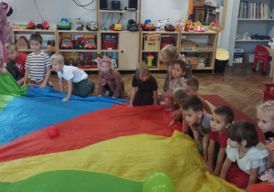 Dzieci klęczą przy chuście animacyjnej