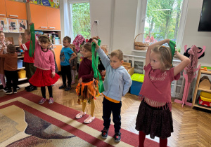 Dzieci trzymają w ręce w górze. Trzymają zielony pasek