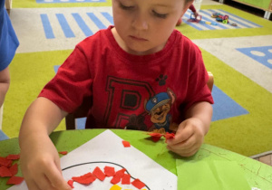 Chłopiec wykonuje prace plastyczną