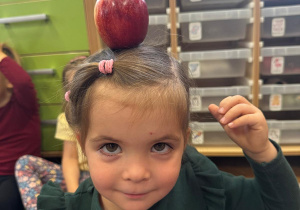 Dziewczyna ma jabłko na głowie