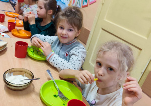 Dzieci siedzą przy stole, jedzą śniadanie