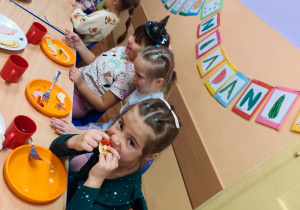 Dzieci siedzą przy stole, jedzą śniadanie