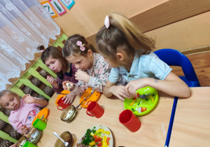 Dzieci siedzą przy stole, jedzą śniadanie