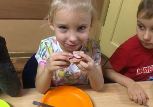 Dzieci siedzą przy stole, jedzą śniadanie