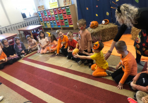 Dzieci siedzą na dywanie