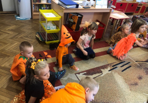 Dzieci siedzą na dywanie