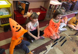 Dzieci siedzą na dywanie