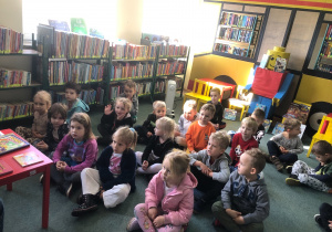 Dzieci siedzą na dywanie