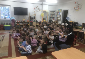 Dzieci siedzą na dywanie