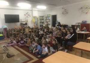 Dzieci siedzą na dywanie