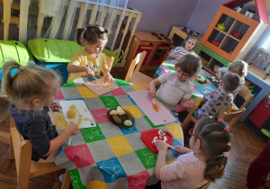Dzieci kroją składniki do sałatki jarzynowej