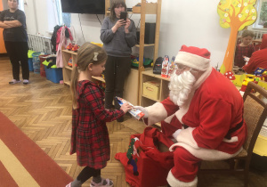 Mikołaj wręcza prezent dziewczynce