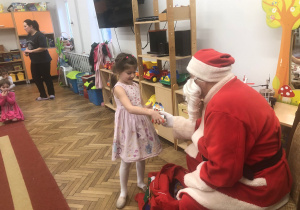 Mikołaj wręcza prezent dziewczynce