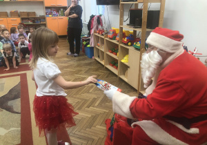 Mikołaj wręcza prezent dziewczynce