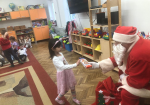 Mikołaj wręcza prezent dziewczynce