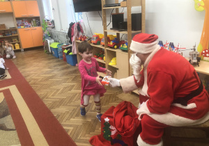 Mikołaj wręcza prezent dziewczynce