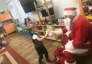 Mikołaj wręcza prezent chłopcu