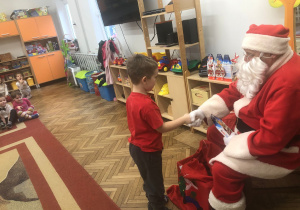 Mikołaj wręcza prezent chłopcu