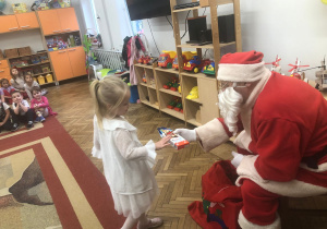 Mikołaj wręcza prezent dziewczynce