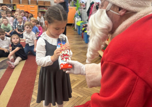 Mikołaj wręcza prezent dziewczynce