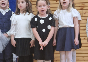 Dzieci stoją i śpiewają