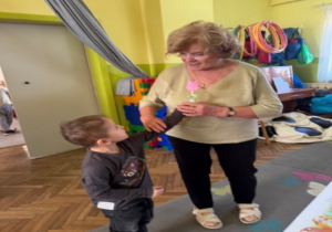 Chłopiec wręcza kwiatka.