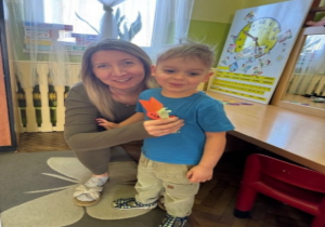 Chłopiec wręcza kwiatka.