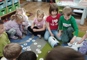 Dzieci oglądają ilustracje z potrawami.