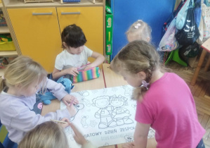Dzieci kolorują obrazki.