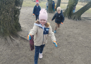 Dziewczynka sprząta śmieci.
