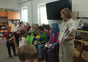 Dzieci wręczają upominki seniorom.