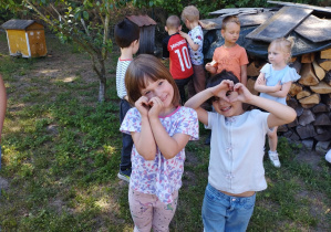 Dziewczynki pokazują serduszka z dłoni.