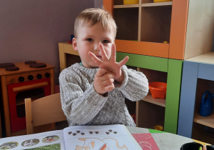 Chłopiec pracuje w książce z kartami pracy