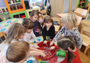 Dzieci maczają palce w misce z wodą